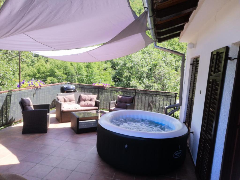 a hot tub on the patio of a house at Apartment D&J in Mošćenička Draga
