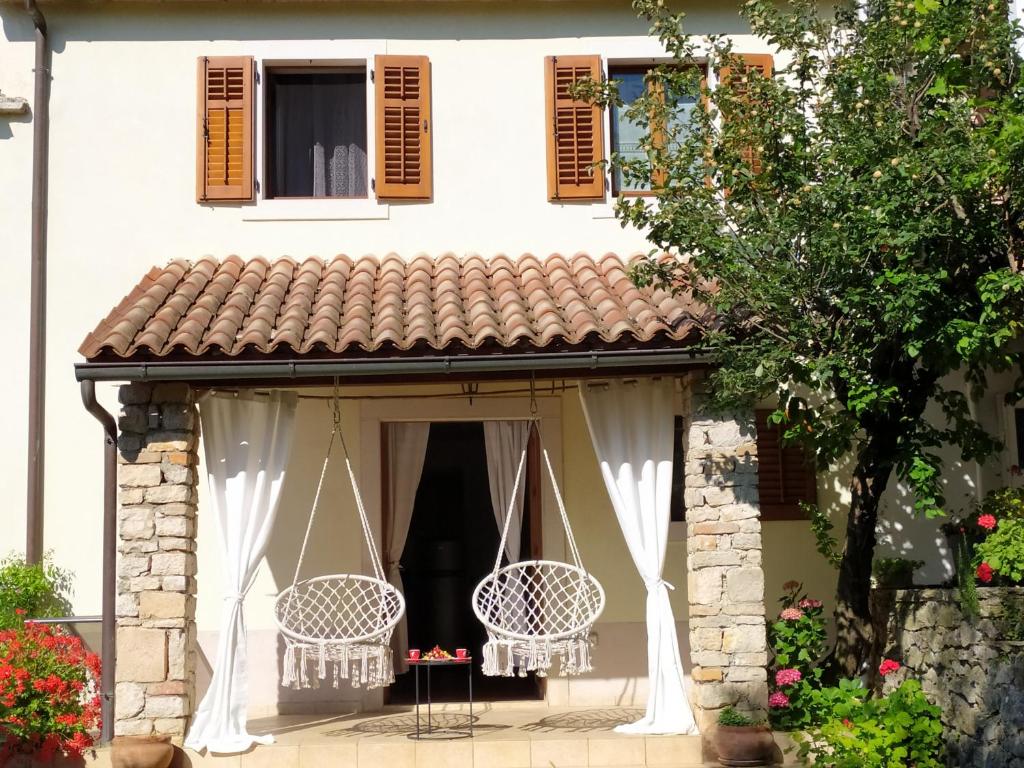 dom z dwoma krzesłami i oknem w obiekcie Apartment PARENZANA, little row HOUSE with big green yard in central Istria w mieście Rakotule