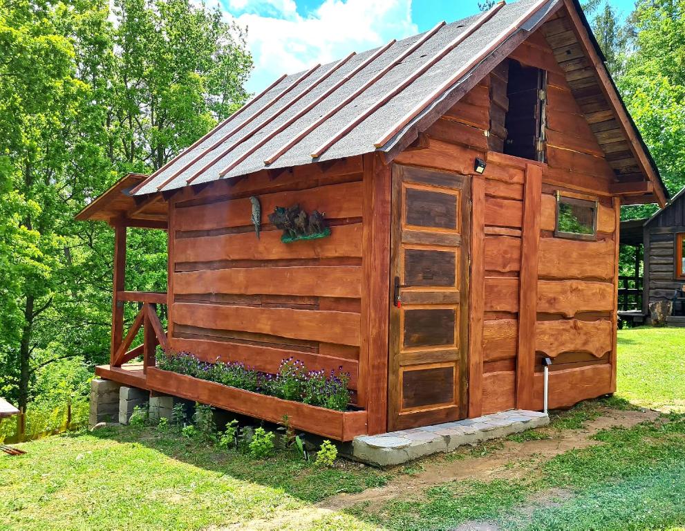 a wooden outhouse with a metal roof at Chatka Gargamela in Mikołajki
