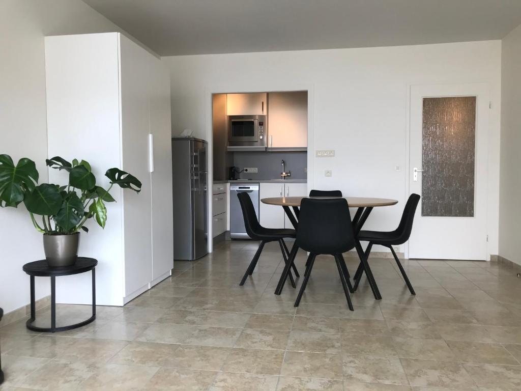 una cucina e una sala da pranzo con tavolo e sedie di cu@thesea a Ostenda