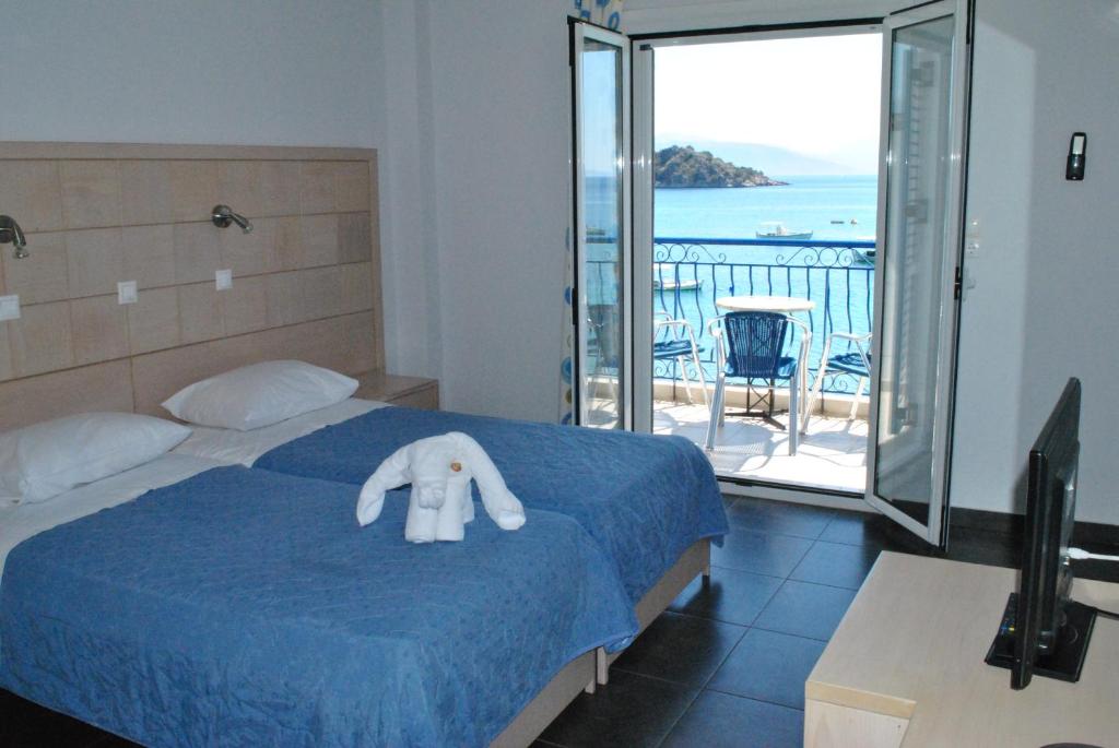 a bedroom with a bed with a stuffed elephant on it at Hotel Aris in Tolo