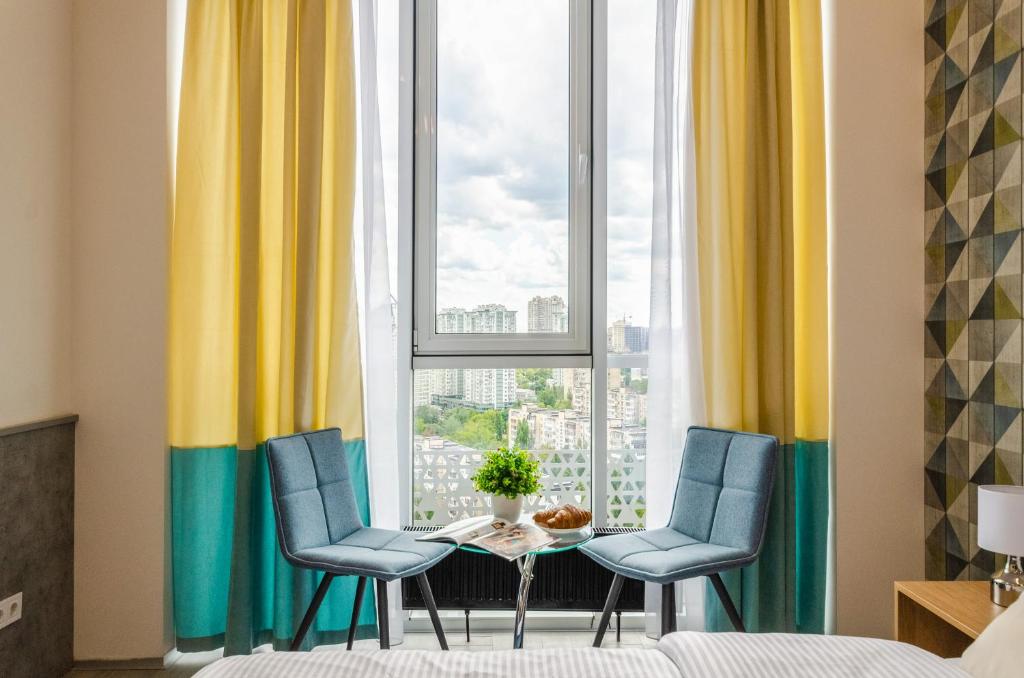 a room with two chairs and a table in front of a window at New Apartment near Railway Station 1A in Kyiv
