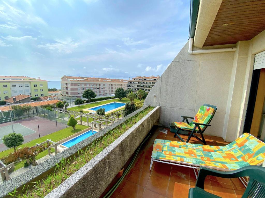 uma varanda com cadeiras e vista para uma piscina em Beachside Feel Full Apartment Beach & Casino em São Félix da Marinha