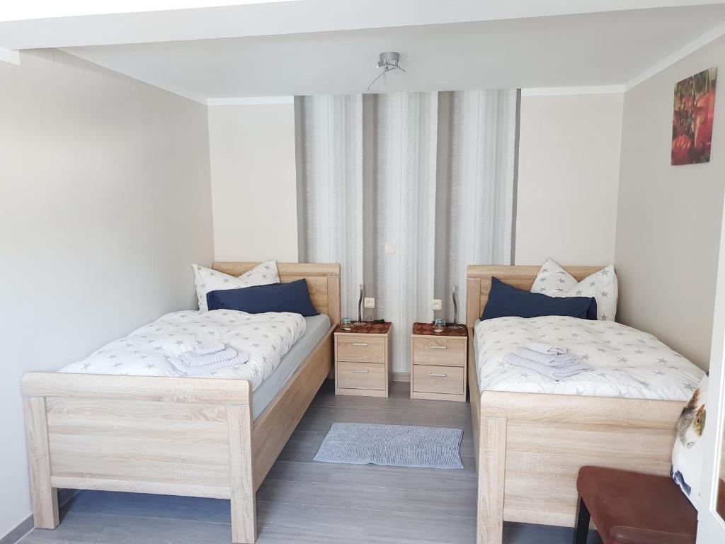 - une chambre avec 2 lits et un miroir dans l'établissement Fremdenzimmer - Petit Quartier, à Merenberg