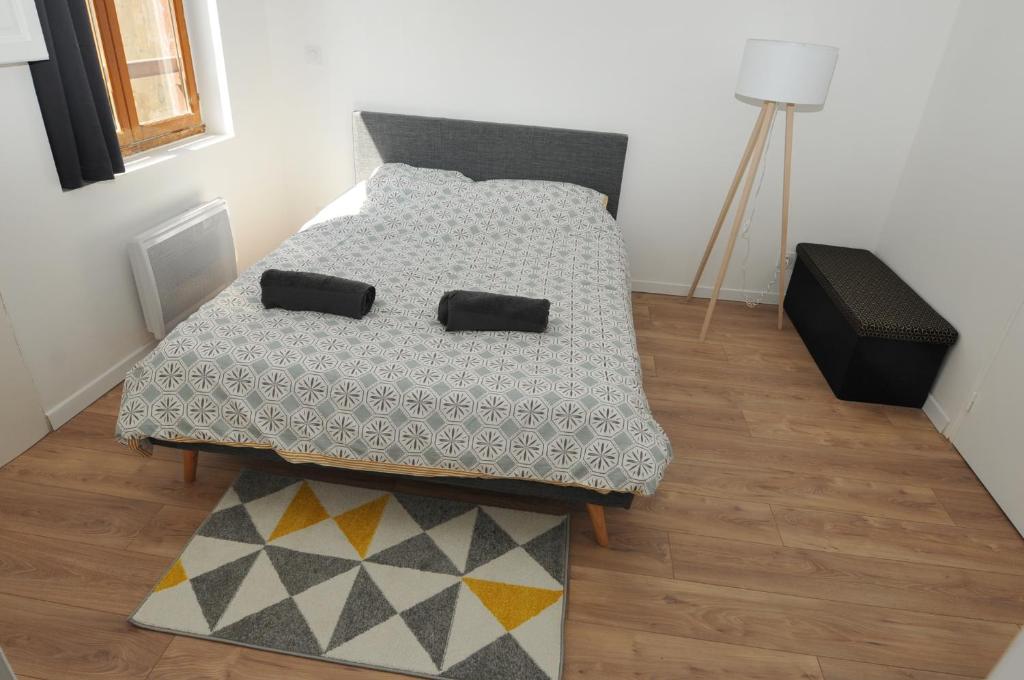 een slaapkamer met een bed met een dekbed en een tapijt bij Près des Bassins, Appartement 35m2 hyper centre Honfleur in Honfleur