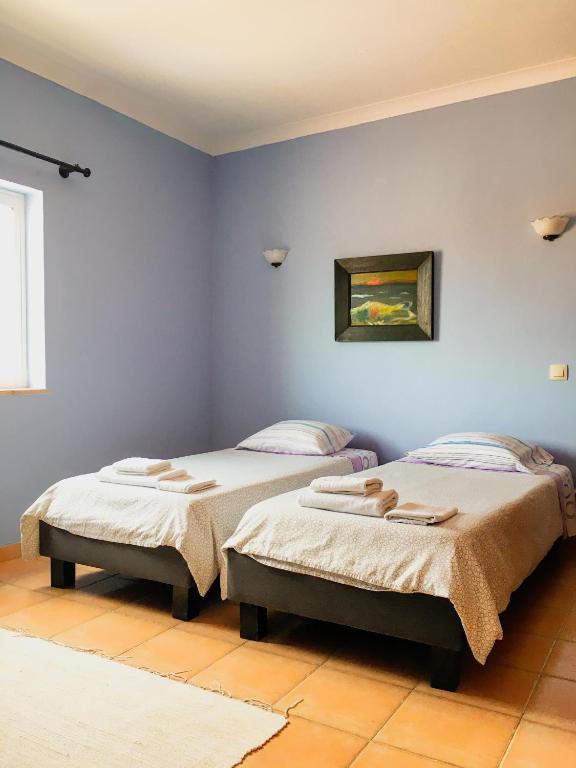 two beds in a room with blue walls at Carrapateira Lodge in Carrapateira