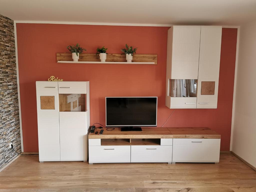 ein Wohnzimmer mit einem TV und weißen Schränken in der Unterkunft Gemütliche 90 qm Wohnung in Saarburg, zentral gelegen, Garten mit Aussicht, separater Eingang in Saarburg