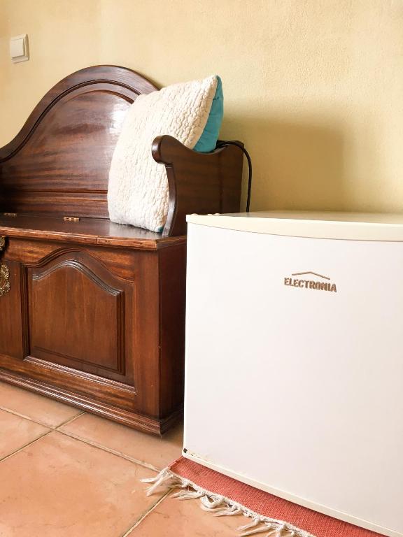 a white box sitting next to a wooden bed at Carrapateira Lodge in Carrapateira