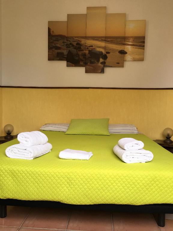 a green bed with towels on top of it at Carrapateira Lodge in Carrapateira