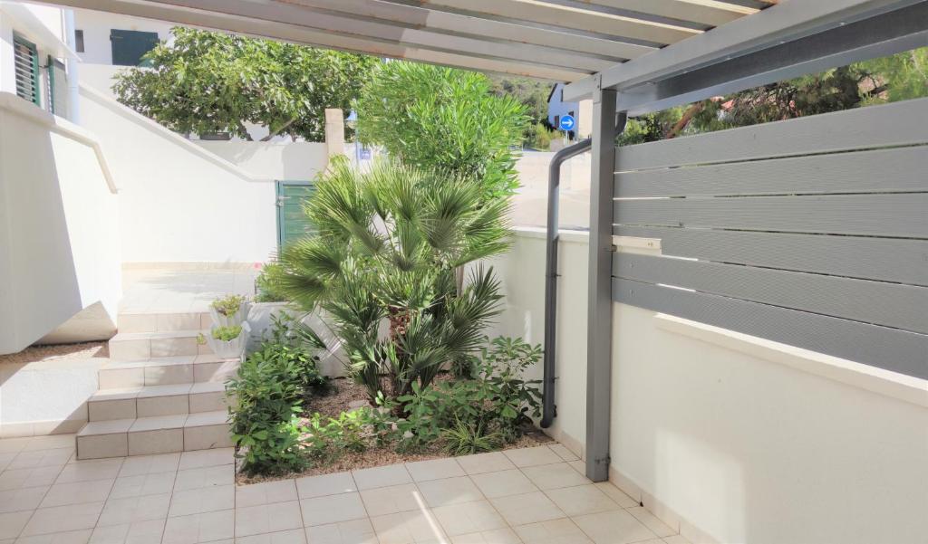 a fence with a palm tree in a courtyard at Apartments Riba in Vis
