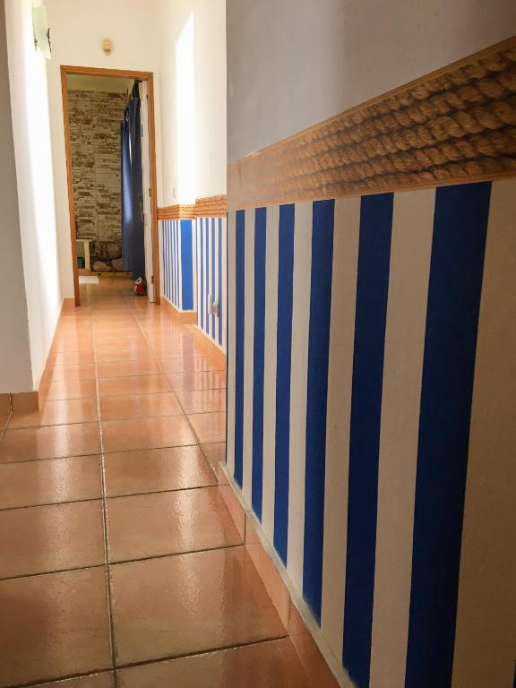 a hallway with blue and white stripes on the wall at Carrapateira Lodge in Carrapateira