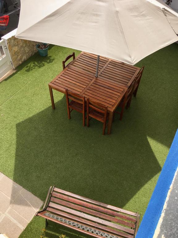 a picnic table with an umbrella and a bench at Carrapateira Lodge in Carrapateira