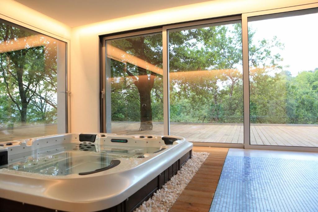 una grande vasca da bagno in una stanza con una grande finestra di Oak Nature a Vieira do Minho