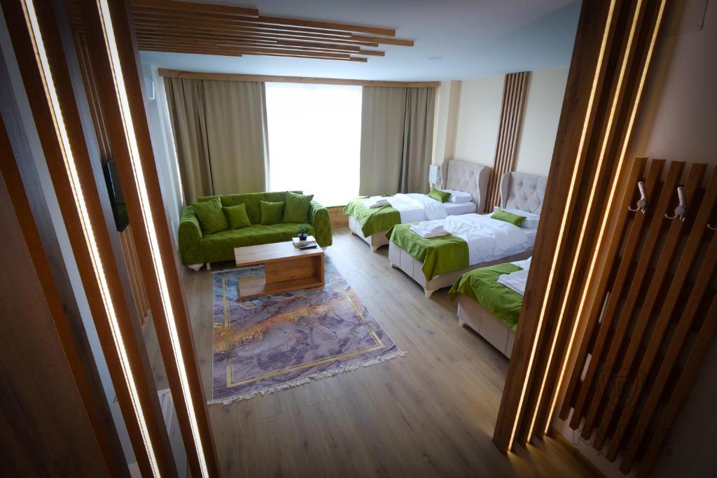 Habitación de hotel con 2 camas y sofá en Motel KVELE, en Novi Pazar