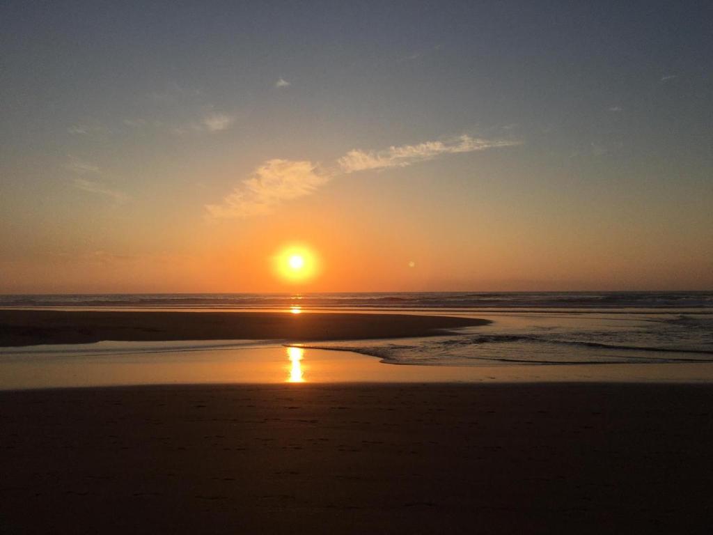 a sunset on the beach with the sun setting at Carrapateira Lodge in Carrapateira