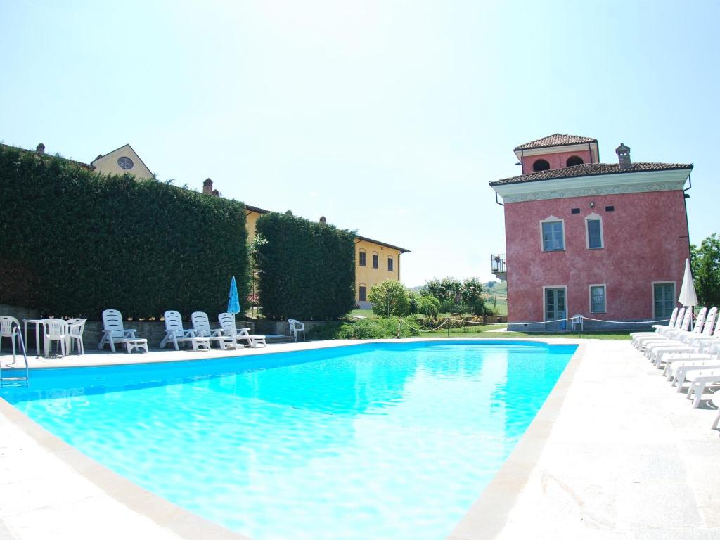 ニッツァ・モンフェッラートにあるModern Mansion in Nizza Monferrato with Swimming Poolのスイミングプール(椅子付)と建物