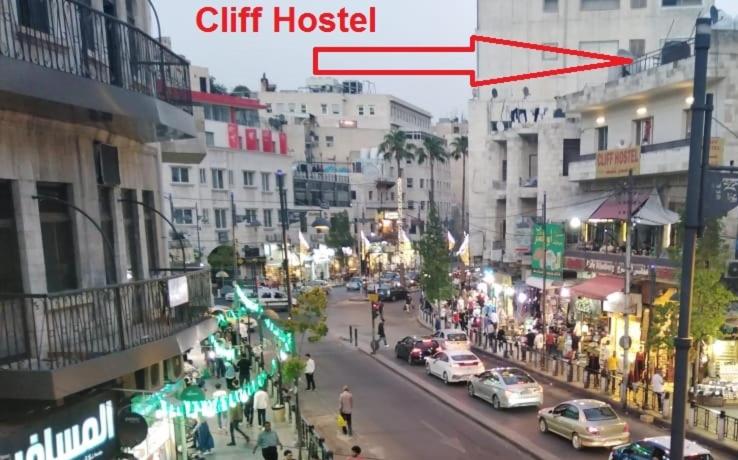 una concurrida calle de la ciudad con coches aparcados en la calle en Cliff Hostel, en Amán