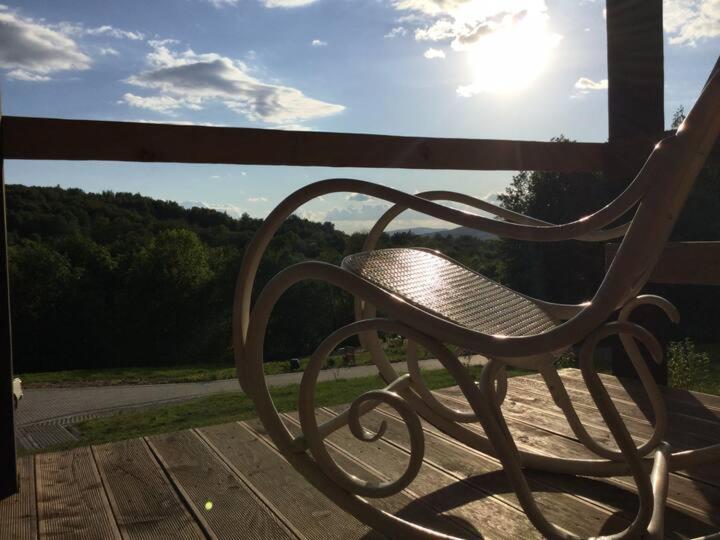 un banco sentado en la parte superior de una terraza de madera en Marzeniec w Beskidzie Niskim en Wapienne