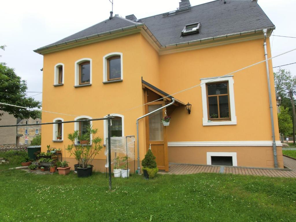 una casa amarilla con un patio delante en FeWo zwischen Augustusburg und Freiberg, en Eppendorf