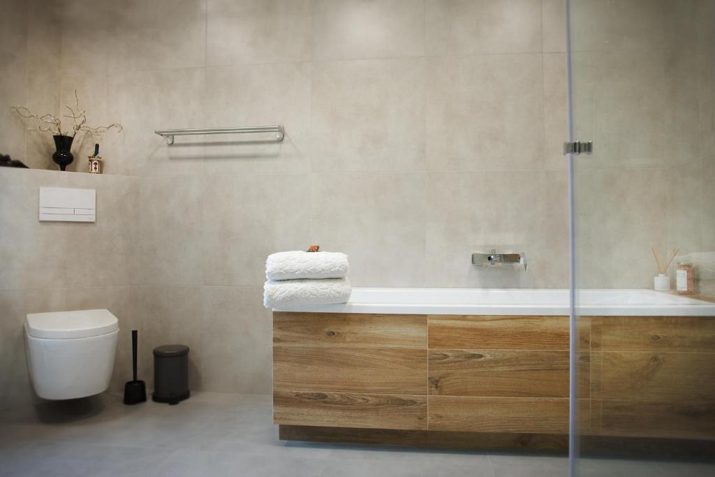 a bathroom with a bath tub and a toilet at Marzeniec pokoje Wapienne w Beskidzie Niskim in Wapienne