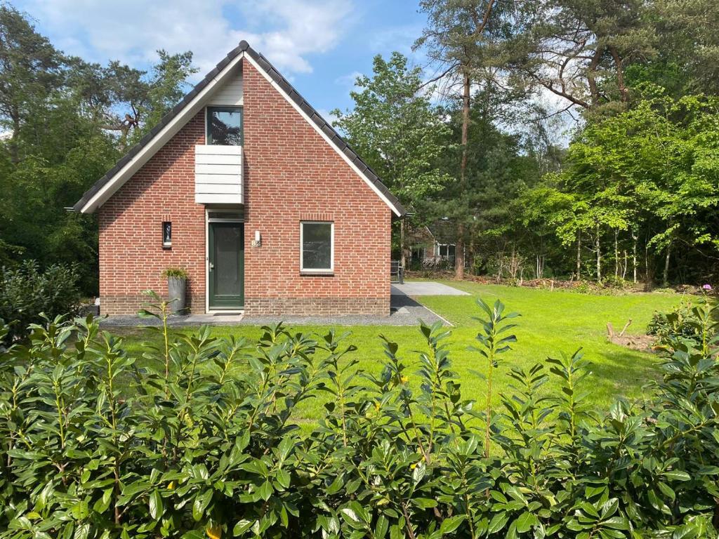una casa de ladrillo con una ventana en un campo en Vakantiehuisje Time Out en Zelhem