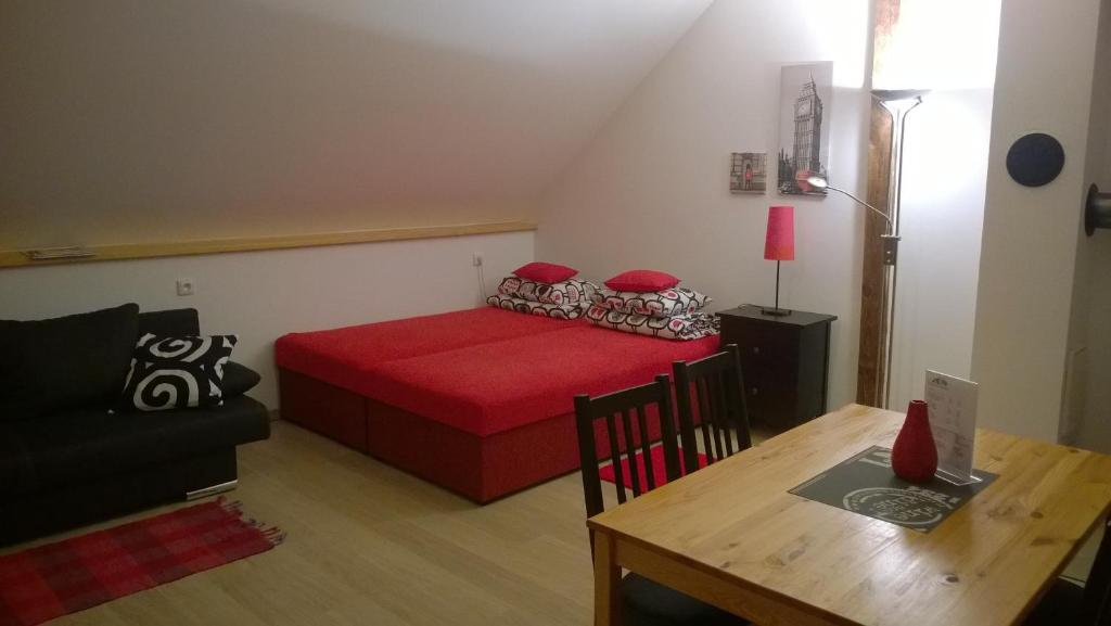 - une petite chambre avec un lit rouge et une table dans l'établissement Studio pro 2 osoby se samostatným vstupem, à Kutná Hora