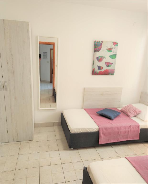 a bedroom with two beds and a mirror at Apartments Riba in Vis