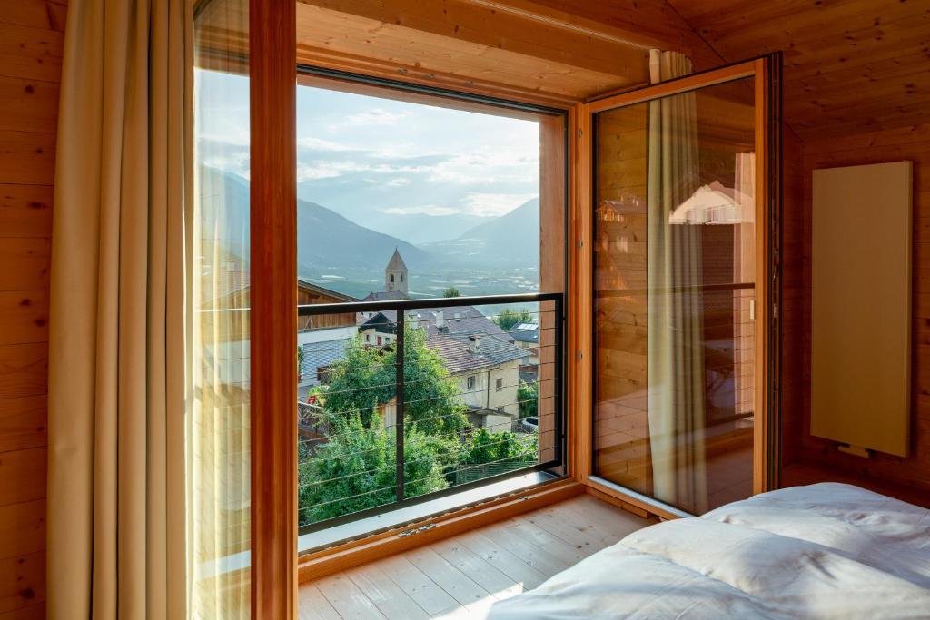 a bedroom with a large window with a view at Zum Riesen Historic Refugium in Laces