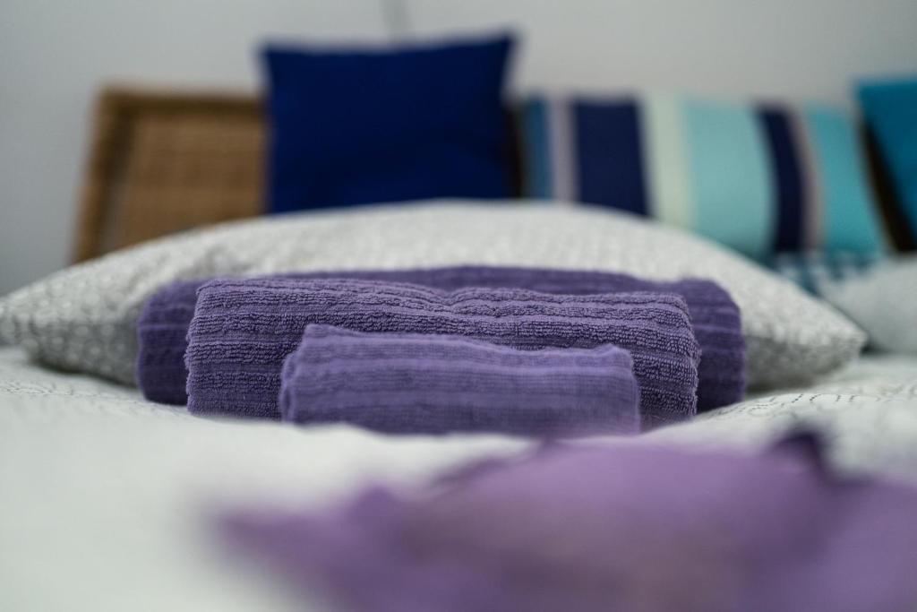 a pile of purple pillows on top of a bed at Apartment Tesla Wizard in Belgrade