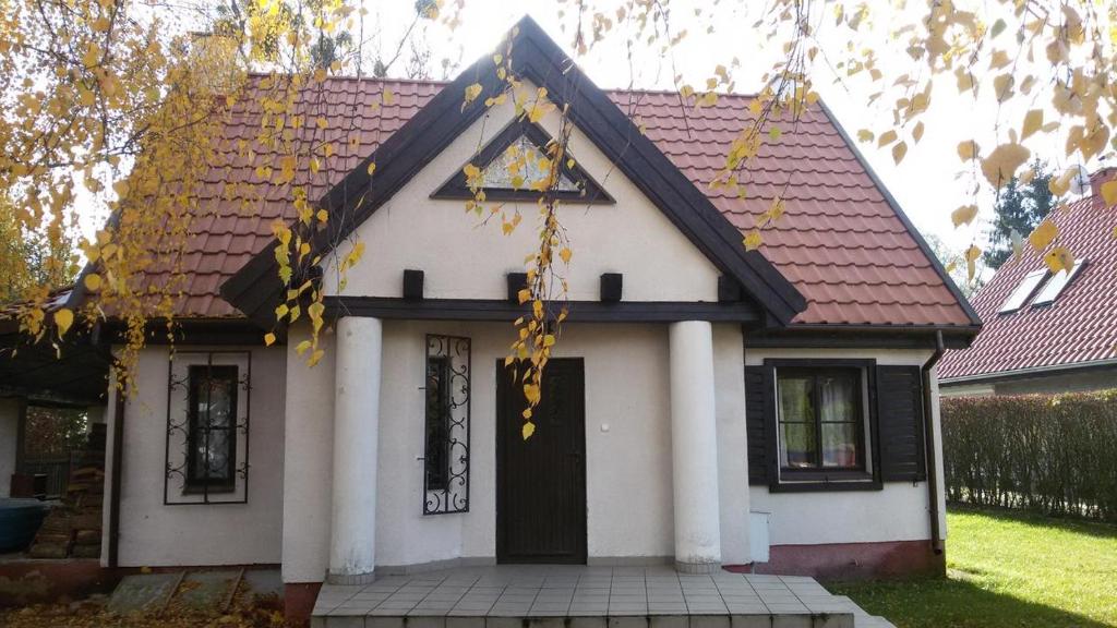 ein kleines weißes Haus mit rotem Dach in der Unterkunft Zbychówka in Kolonia Rybacka