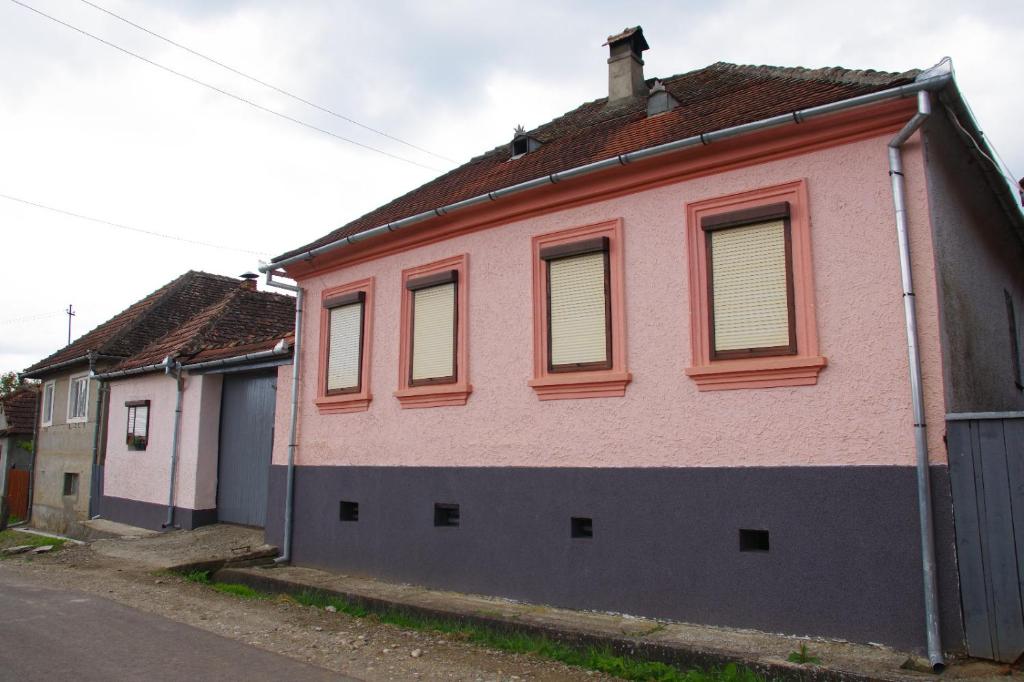 a pink building with windows on a street at Casa Maior 