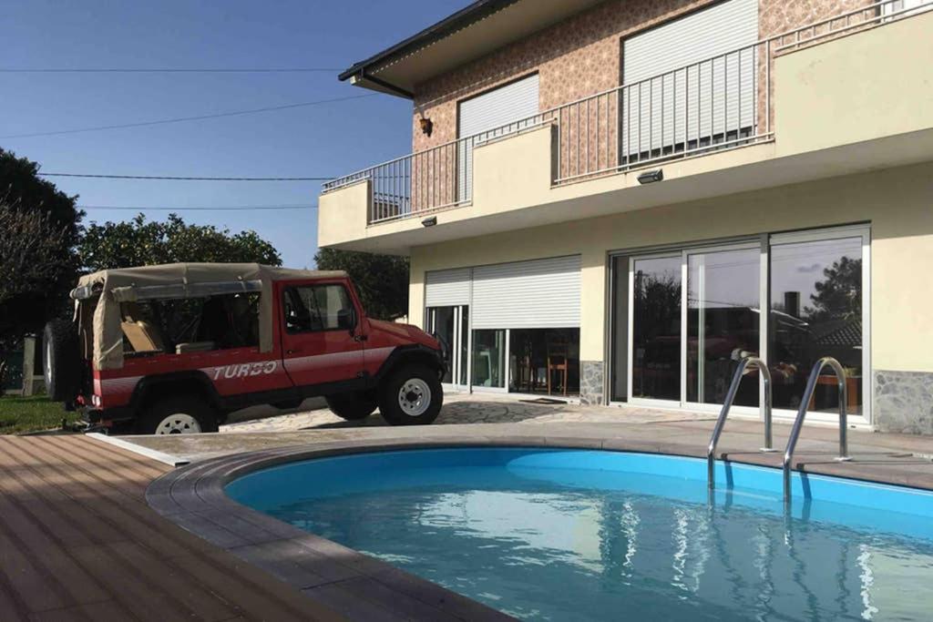 a truck parked in front of a house with a pool at Casa da Cavada - 6 quartos-rooms in Caminha
