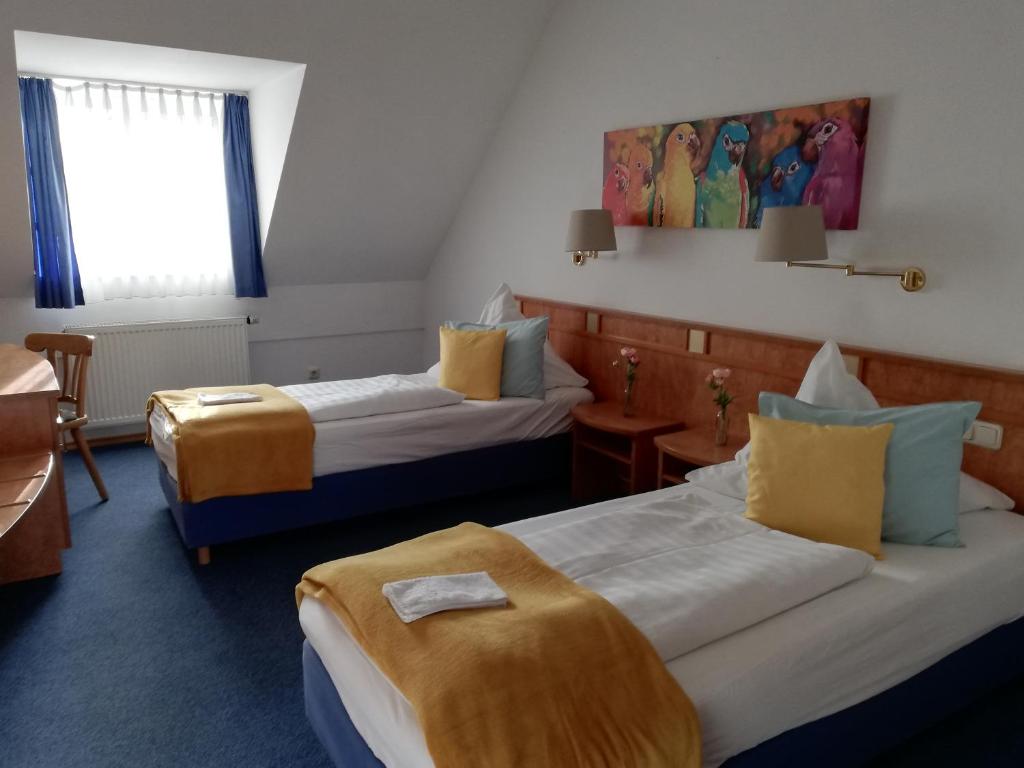 a hotel room with two beds and a desk at Moosburger Hof in Moosburg