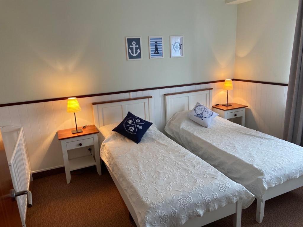 two beds in a room with two lamps on tables at Apartament Villa Baltic - Chalupy in Chałupy