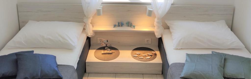 a bedroom with two beds with white pillows at Apartments Riba in Vis