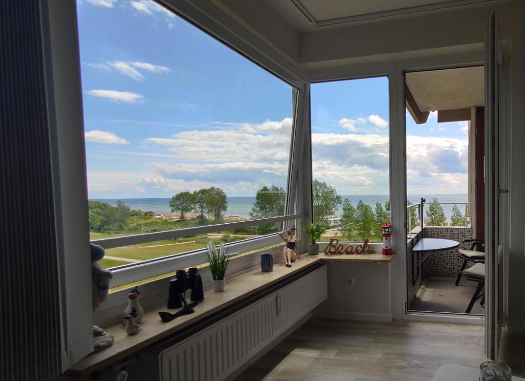 a room with a large window with a view of the ocean at Grömitz am Meer in Grömitz