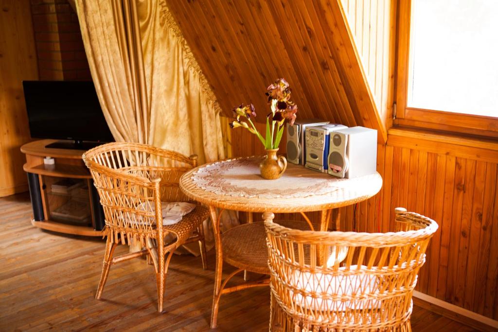 une petite table avec un vase de fleurs dessus dans l'établissement Brīvdienu māja Ezera Sonāte, à Bērzgale