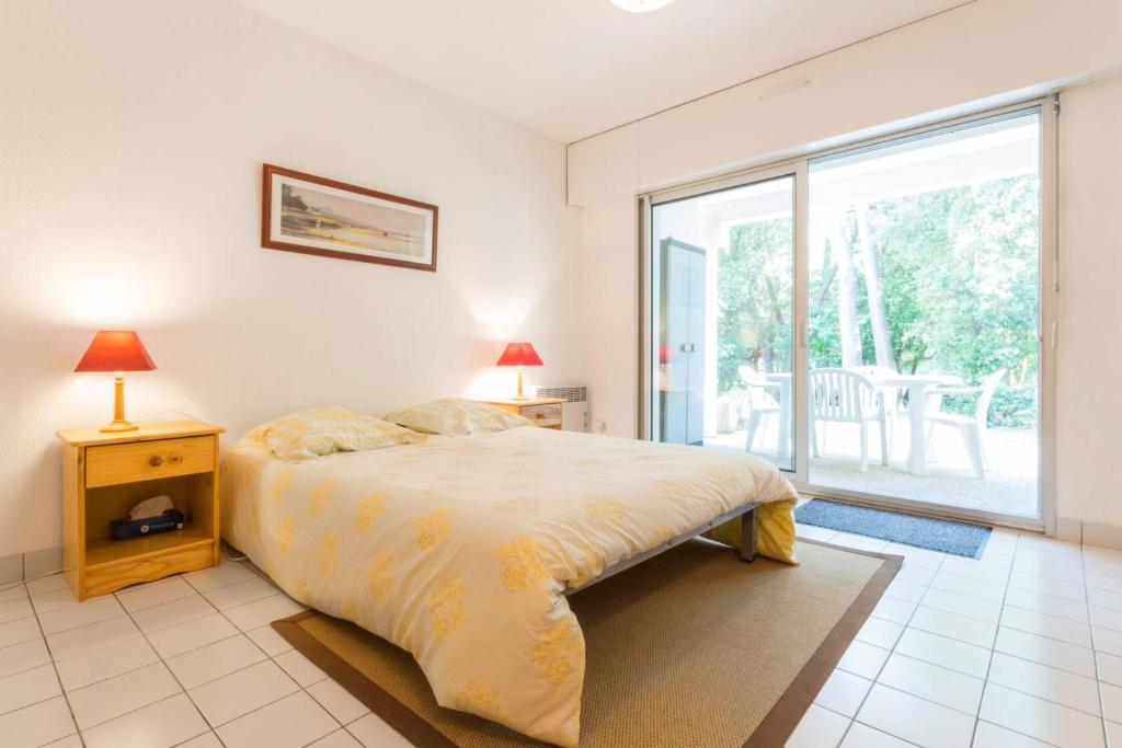 une chambre avec un lit et une grande fenêtre dans l'établissement Les jardins de sainte Marguerite, à Pornichet