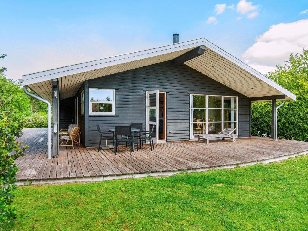 a house with a wooden deck with a roof at 6 person holiday home in Ebeltoft in Femmøller