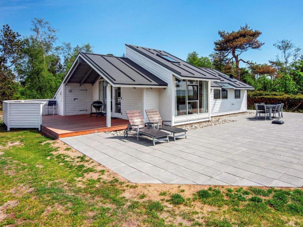 a house with a deck and a patio at Three-Bedroom Holiday home in Knebel 22 in Knebel
