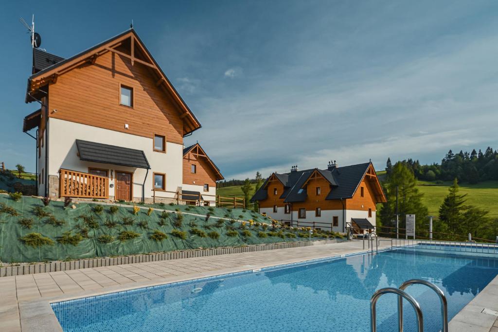 a large swimming pool in front of a house at Nasze Bukowinki in Jaworki