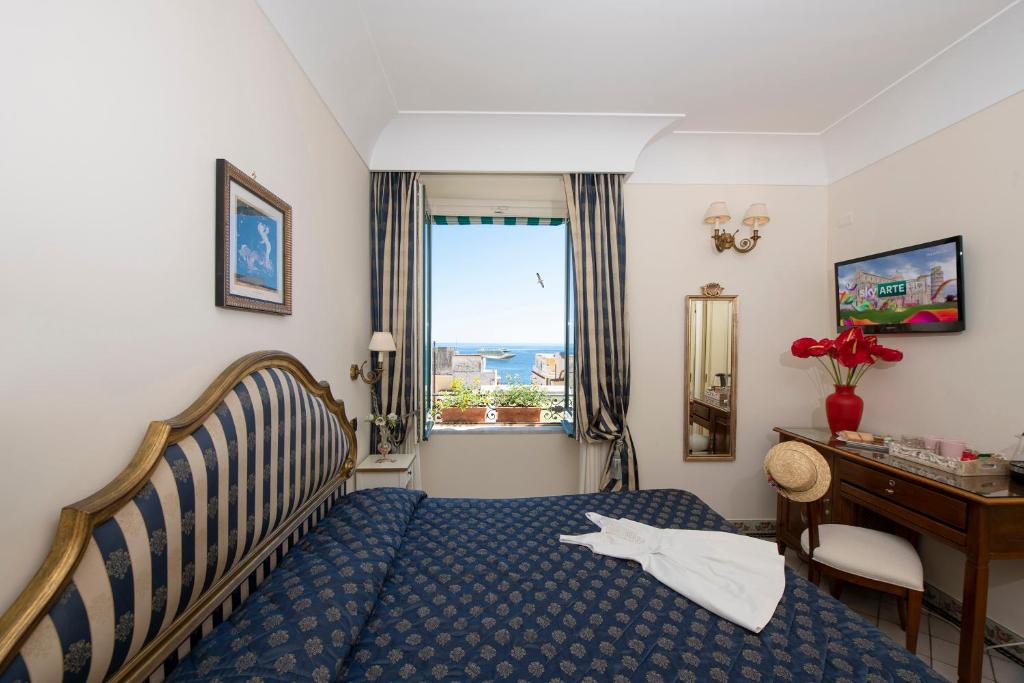 - une chambre avec un lit, un bureau et une fenêtre dans l'établissement Amalfi Old Square room & apartments, à Amalfi