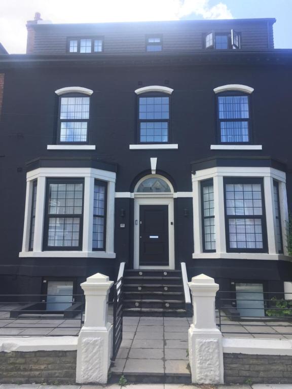 a black house with white windows and a door at Huntley lodge pp in Liverpool