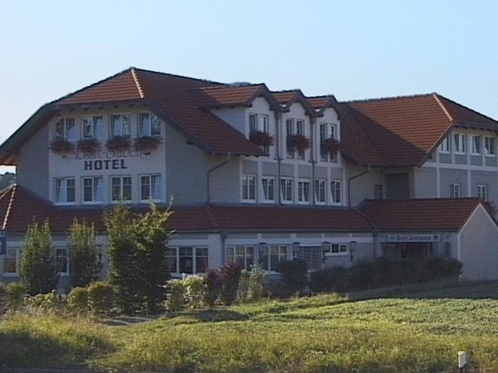 um grande edifício com um hotel no topo de um campo em Mozart-Stuben em Denkendorf
