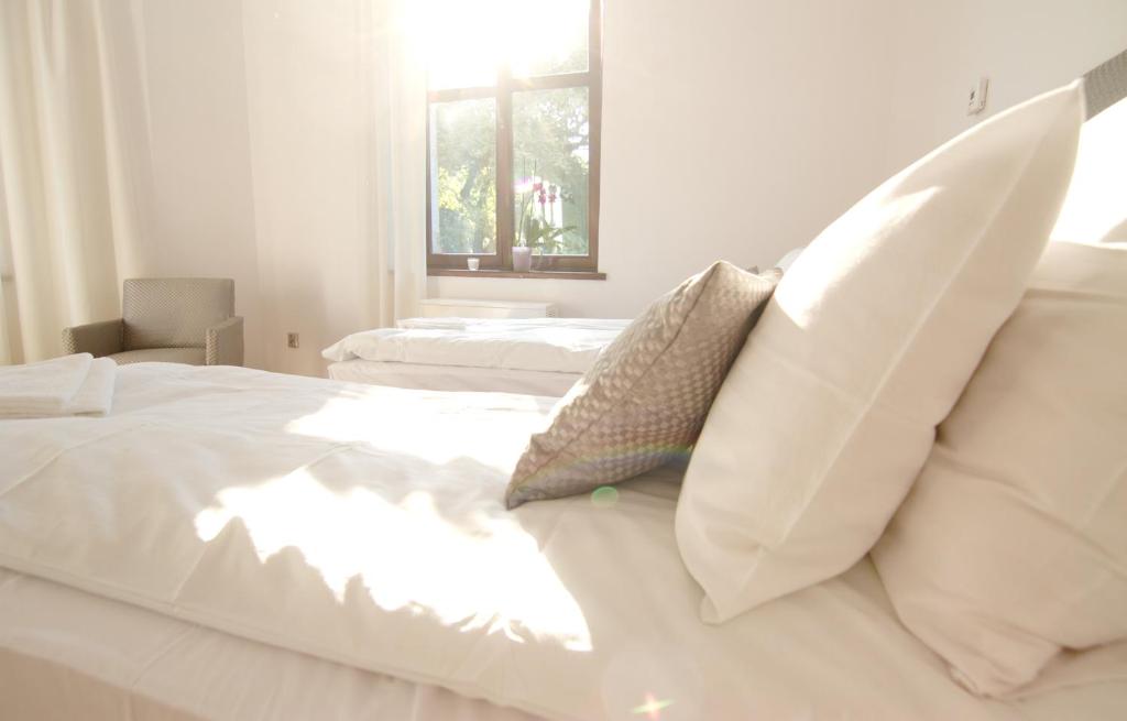 um quarto com 2 camas com lençóis brancos e almofadas em Cracow bb em Cracóvia