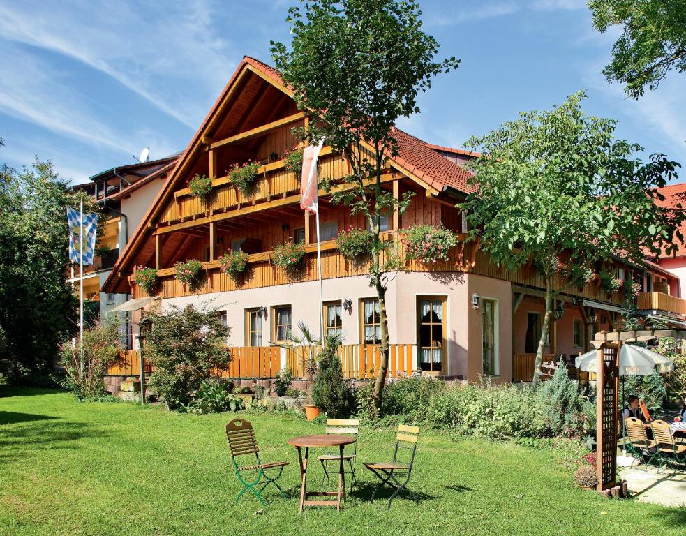a building with a table and chairs in the yard at Land- und Aktivhotel Altmühlaue in Bad Rodach