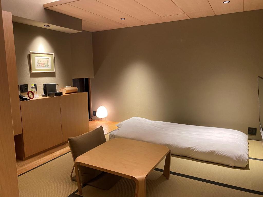 Postel nebo postele na pokoji v ubytování Kaminarimon Ryokan