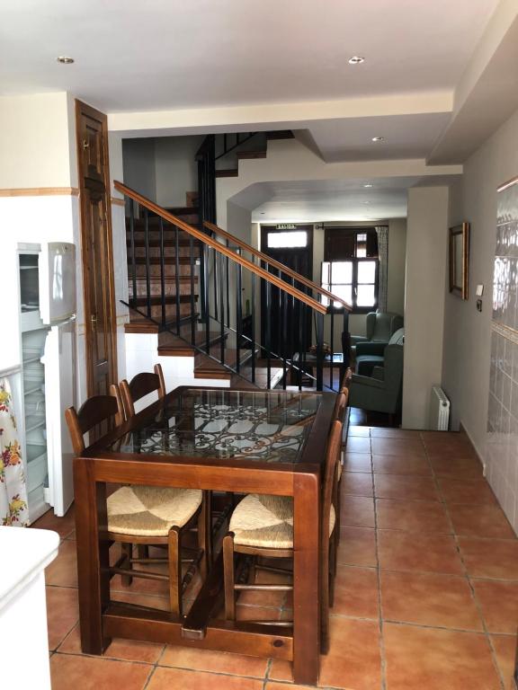 a dining room with a table and chairs and a staircase at La casa de Tita Elvira 2 in Zafarraya