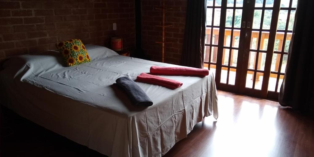 un letto con due cuscini sopra in una stanza di Chalés Roma a Santo Antônio do Pinhal