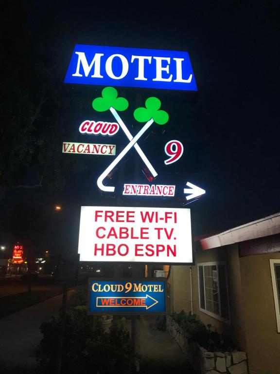a neon sign for a motel with a sign for at Cloud 9 in Cypress